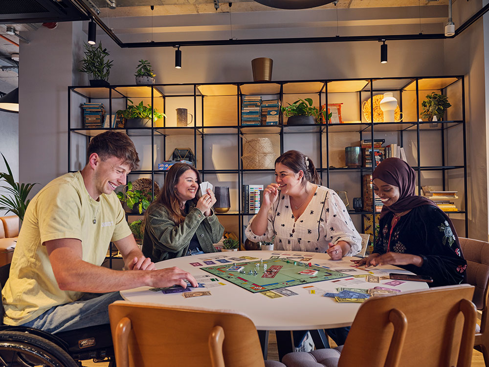 Students playing monopoly at the table
